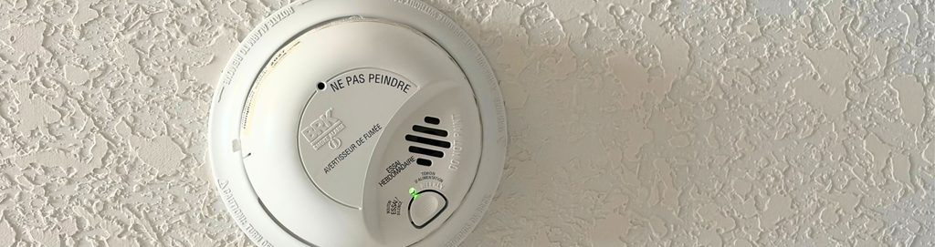 A close up image of a properly functioning CO Detector. A green light is shown, showing it's armed and ready.