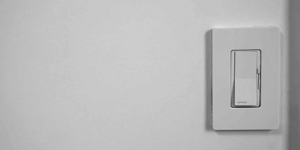 Rocker with slide dimmer on blank white wall.