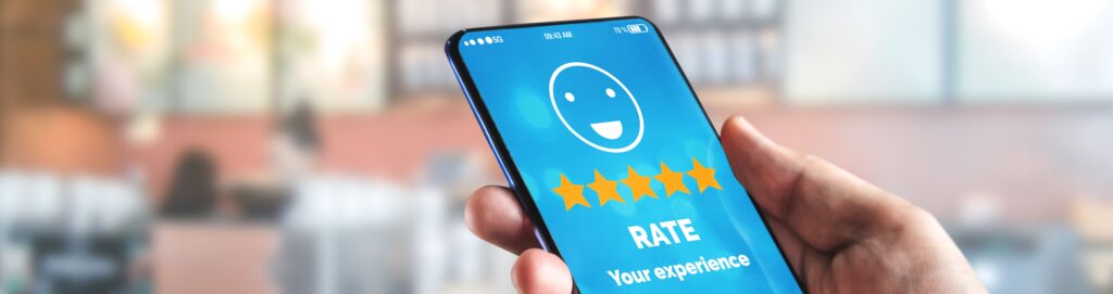 A close up image of a person holding a phone. On the screen is an app asking the homeowner to rate their experience.