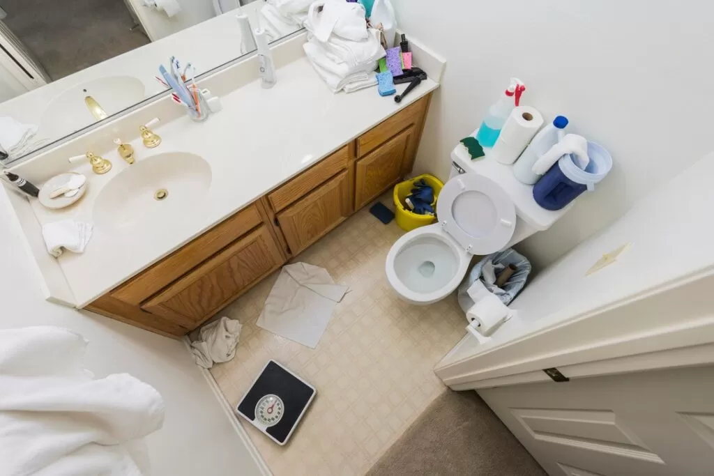 Cluttered bathroom in the process of being cleaned