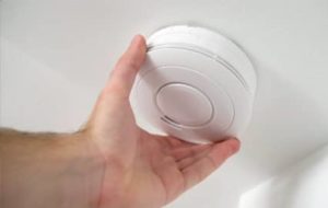 Tech installing smoke detector