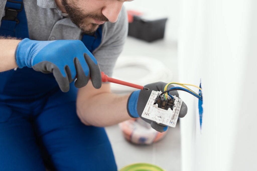 Electrician installing wall socket in home