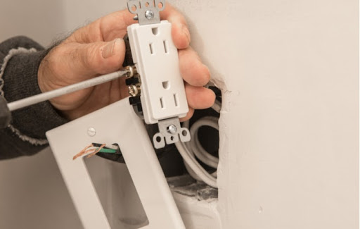 Close up of mans hand replacing old electric outlet at home