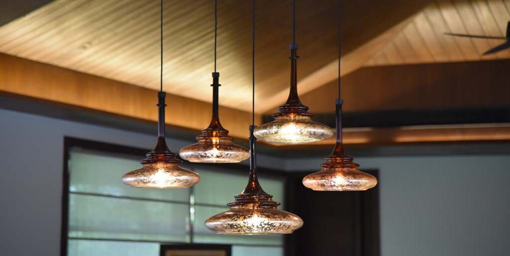 Five ornamental halogen lights hanging in an elegant home.