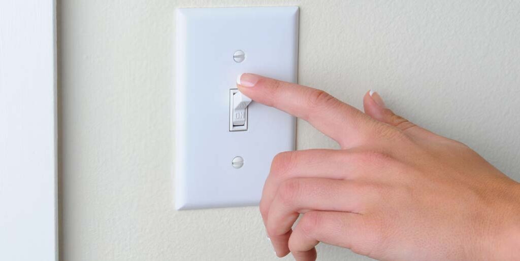 Hand turning light switch.