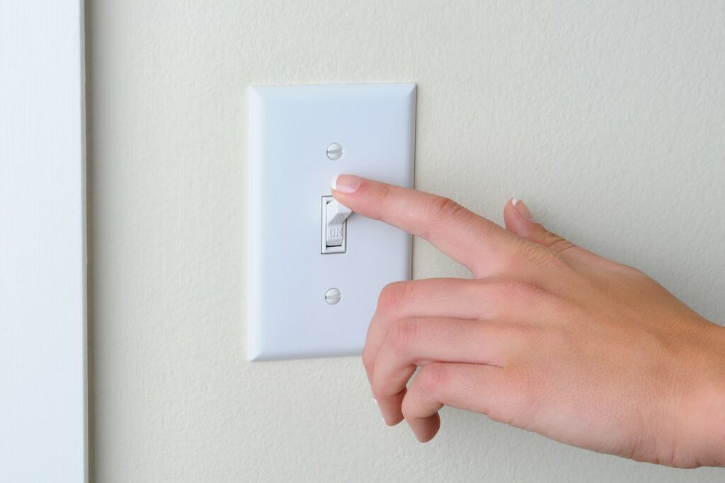 Hand turning light switch.