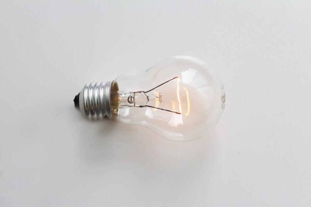 Clear incandescent light bulb laying on a white table