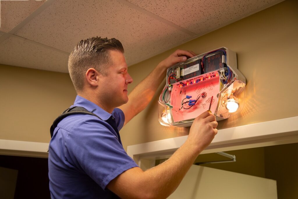 Electrician working on light fixture