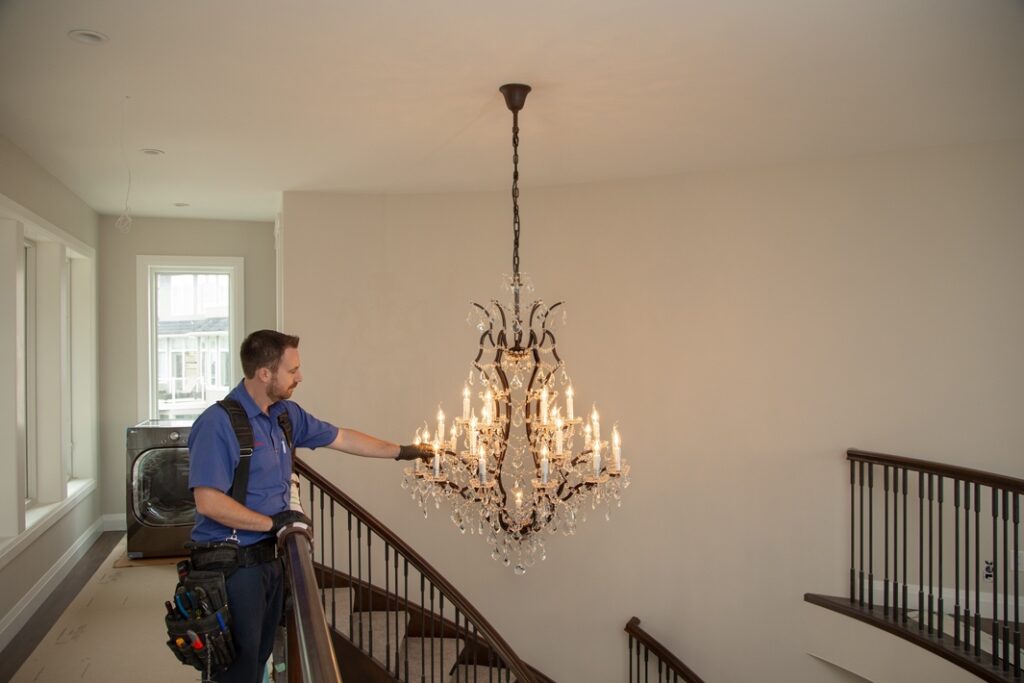 Electrician working on chandelier lights.