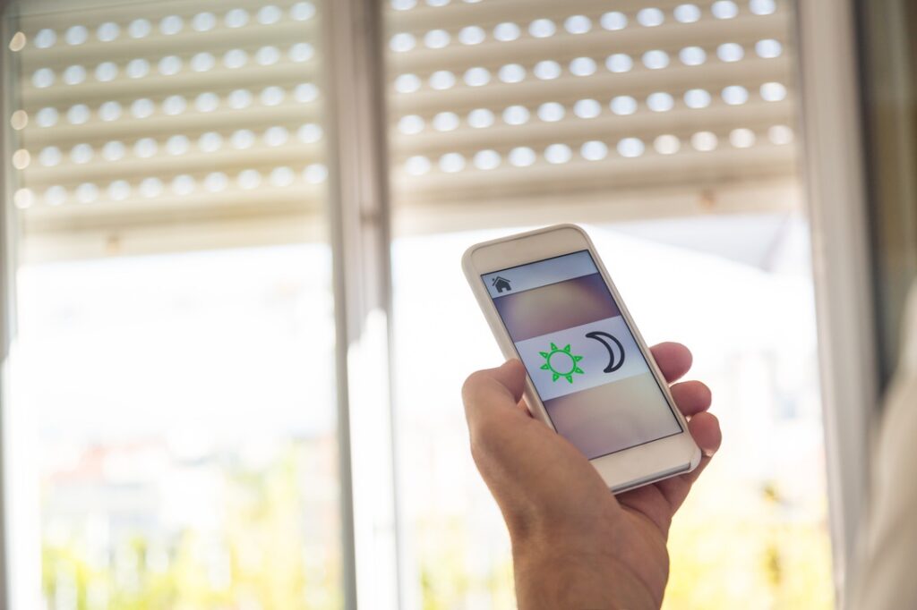 Smart home: man controlling blinds with app on his phone