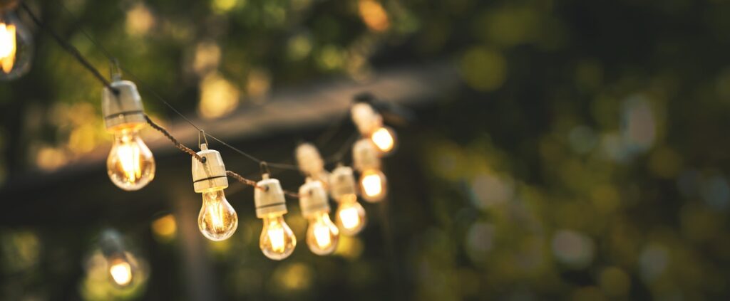 outdoor party string lights hanging on a line in backyard with copy space