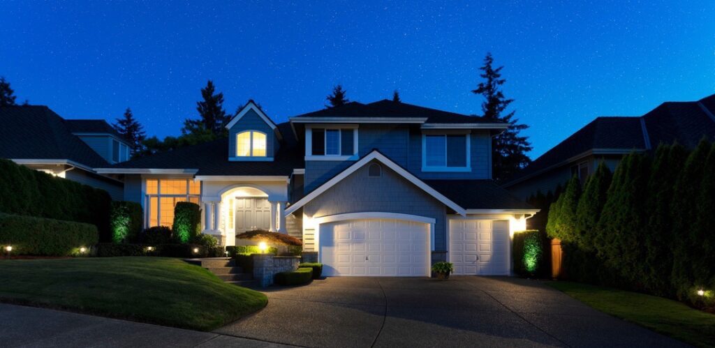 Home at night with lights on to represent common demands placed on electrical panels
