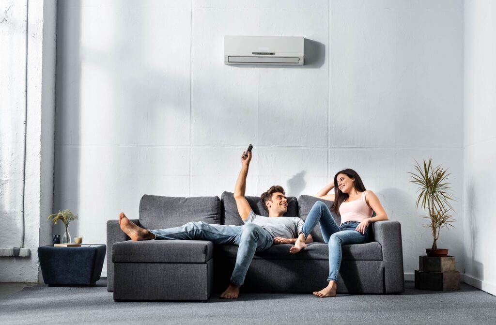 Couple sitting under ductless mini-split air conditioner in living room