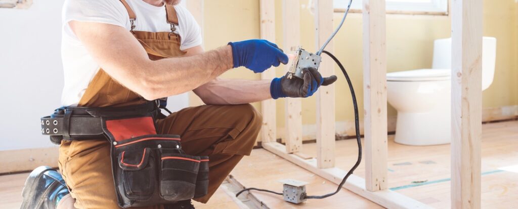 Electrician working on outlet in older home