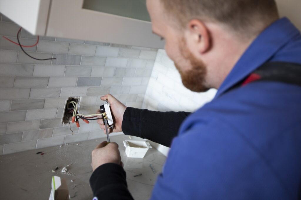Electrical contractor working in residential home after pulling required contractor permit
